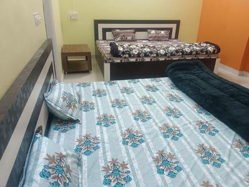 twee bedden in een slaapkamer met een dekbed erop bij Saraswati Sadan Homestay Ayodhya in Faizābād