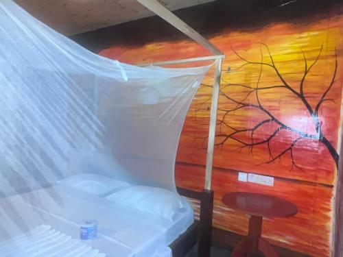 Cette chambre dispose d'un lit et d'une peinture murale. dans l'établissement Maweni CoralBay Beach Villa, à Kilindoni