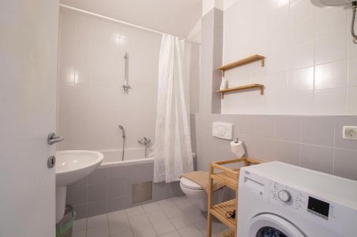 een witte badkamer met een wastafel en een toilet bij Bright loft near Bohinj lake in Bohinj