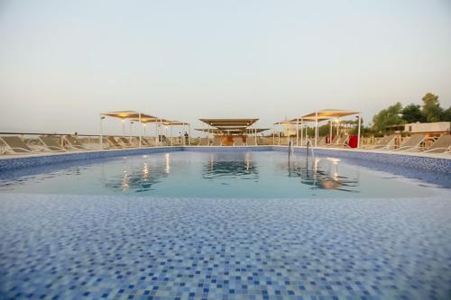una gran piscina con sillas y sombrillas en Orient MS Grand Rose en Luxor