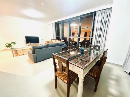 een woonkamer met een tafel en een bank bij BJ's luxury Burj and Creek View 2 BR Apartment in Dubai