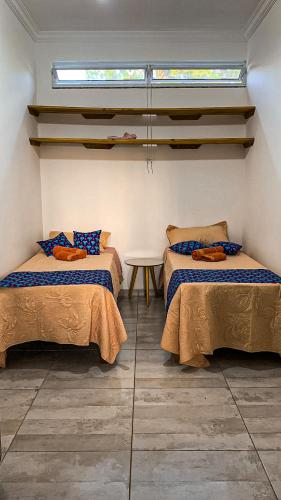 a room with two beds and a table in it at Refúgio Vila da Glória in São Francisco do Sul