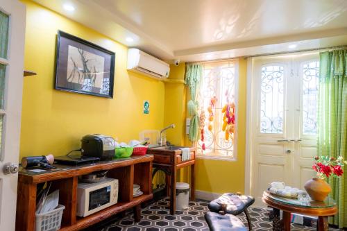 sala de estar con paredes amarillas y microondas en Our HomeStay, en Hai Phong