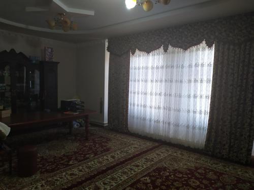 a living room with a window and a table at Дачный домик in Tashkent