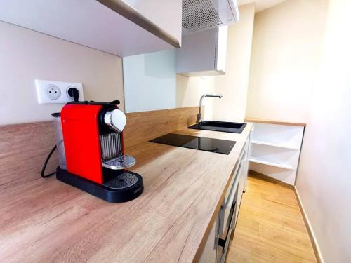 une cuisine avec un appareil rouge au-dessus d'un comptoir dans l'établissement Studio cosy - Proche mer et gare, à Nice