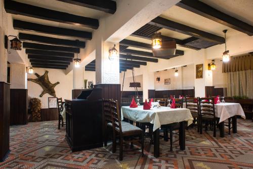 un restaurante con mesas y sillas con servilletas rojas. en Hotel Bucegi, en Sinaia