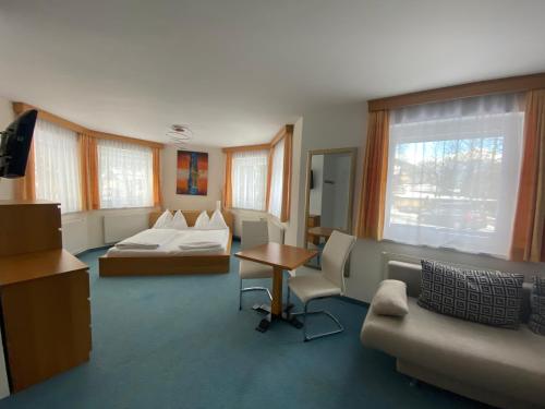 a room with a bed and a couch and a table at GRUBERS, Hotel Appartments Gastein in Bad Gastein