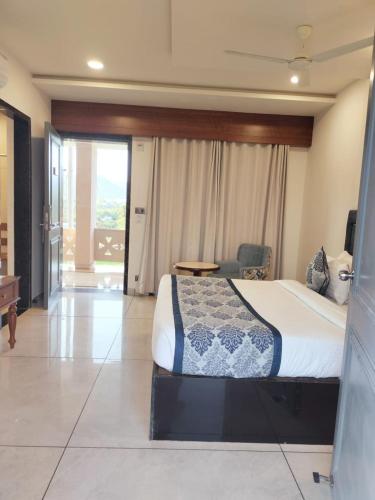 a bedroom with a bed and a desk and a table at Traavista Aravali Mahal - Luxury Lake View Heritage Resort in Udaipur in Udaipur