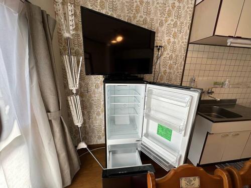 una nevera con la puerta abierta en una cocina en A201.KASUMI-an 花, en Shimo-tatsuda