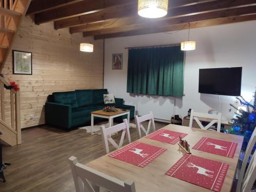 a living room with a table and a christmas tree at Dzika Polana in Duszniki Zdrój