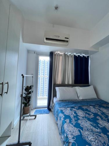 a small bedroom with a bed and a window at Studio Units at SM Light Residences Condo Beside Boni MRT Station in Manila