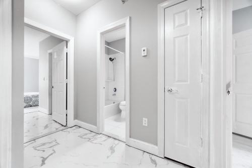 een witte badkamer met witte muren en witte marmeren vloeren bij Waterfront Gem Duplex 3 Bedroom 2Floor in Whitestone Bronx Free parking in College Point