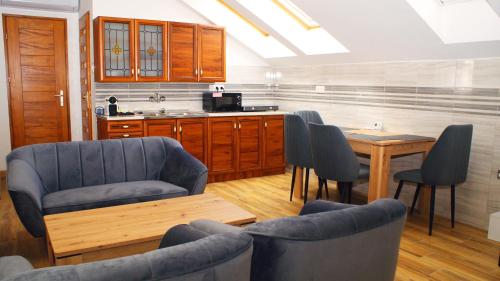 Pokój z krzesłami i stołem oraz kuchnią w obiekcie Liget Apartman w mieście Pusztaszabolcs