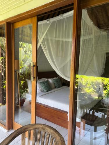 a porch with a bed in a room at Depong House in Ubud