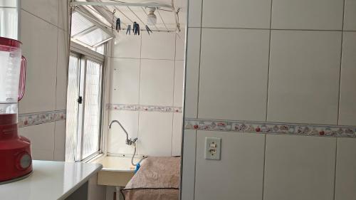 une cuisine avec un comptoir et une fenêtre. dans l'établissement Refúgio Santista - sua casa fora de casa com estacionamento, à Santos