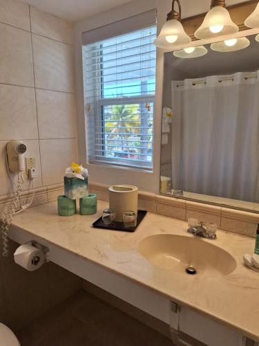 a bathroom with a sink and a mirror at Sibonne Beach Hotel in Grace Bay