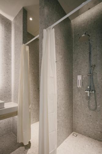 a bathroom with a shower with a shower curtain at Matini Hostel grandstation in Bang Su