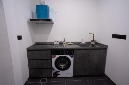 a washing machine in a kitchen with a counter at Danzha Motel Erbil in Erbil