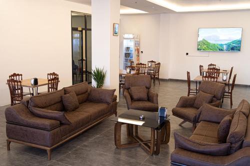 ein Wohnzimmer mit Sofas, einem Tisch und Stühlen in der Unterkunft Motel Danzha in Erbil