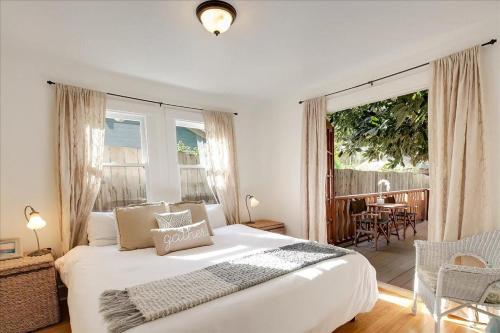 a bedroom with a large white bed and a balcony at Hammonds Beach Haven in Santa Barbara
