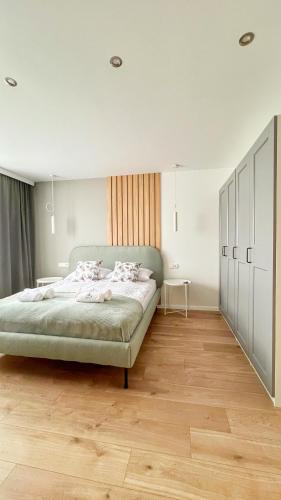a bedroom with a large bed and a wooden floor at Gojka Apartamenty in Piekielnik