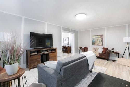 a living room with a couch and a tv at South Bend Serenity: Freshly Renovated 3BR 2mi ND in South Bend