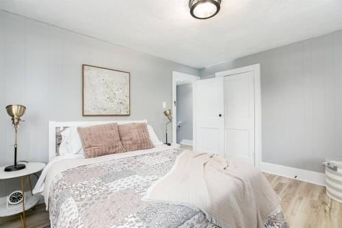 a white bedroom with a bed and a white cabinet at South Bend Serenity: Freshly Renovated 3BR 2mi ND in South Bend