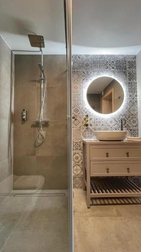 a bathroom with a shower and a sink and a mirror at Gojka Apartamenty in Piekielnik