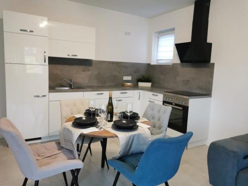 a kitchen with a table and chairs and a kitchen with white cabinets at LOOT: Moderne Wohnung / Zentral in Kitzingen