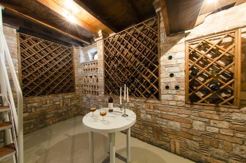 Aeolos Villa في Koumeika: قبو للنبيذ مع طاولة بيضاء أمام جدار من الطوب