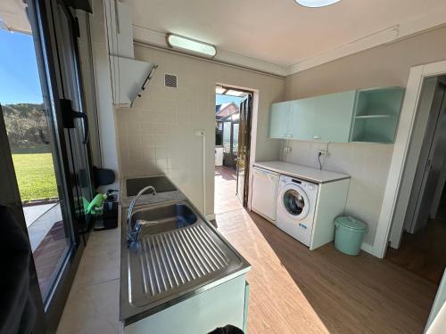 eine Küche mit Spüle und Waschmaschine in der Unterkunft CHALET ENTRE DOS PLAYAS TAPIA in Tapia de Casariego