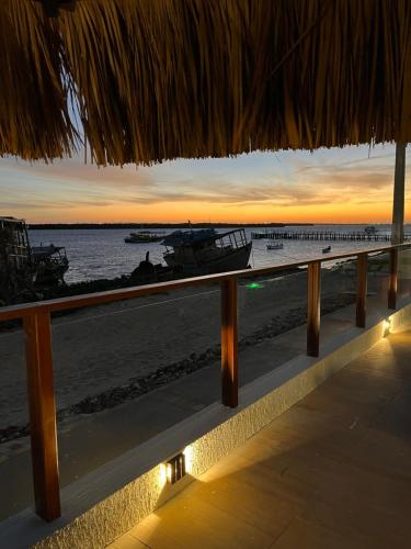 een uitzicht op het strand bij zonsondergang vanuit een resort bij Pousada Rio Aratuá in Galinhos