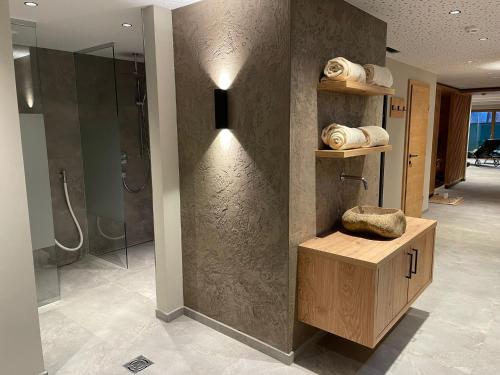 a bathroom with a shower and a bench with a rock at Resort Schrofenblick in Mayrhofen