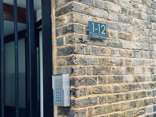 a brick wall with a remote control on it at Town Centre Modern 1 Bed 1 Bath Apartment at Potter House by Lord Property in Aldershot