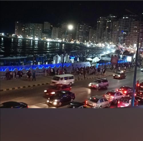 um grupo de carros estacionados num parque de estacionamento à noite em شقه عالبحر بجوار هيلتون عاءلات فقط em Alexandria