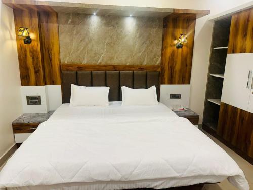 a bedroom with a large bed with white sheets at YATRI NIVAS SAGARA ( AC AND NON-AC DELUXE ROOMS) in Sāgar