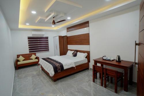 una camera da letto con un letto, un tavolo e una scrivania di UNIVERSAL RESIDENCY a Perumpāvūr