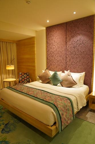 a hotel room with a large bed with pillows at Hotel Royal Orchid Jaipur, Tonk Road in Jaipur
