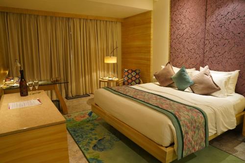a hotel room with a bed and a desk at Hotel Royal Orchid Jaipur, Tonk Road in Jaipur