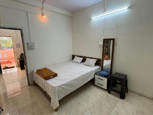 a small bedroom with a bed and a mirror at Daulatabad Guest House in Daulatābād