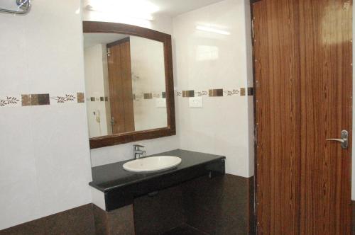 a bathroom with a sink and a mirror at Hotel Blue Star in Coimbatore