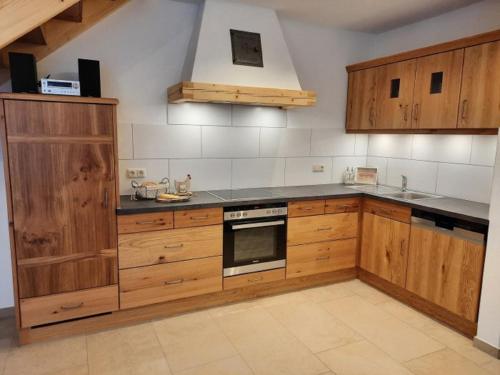 a kitchen with wooden cabinets and a stove top oven at Moarhof Holzhausen in Holzhausen