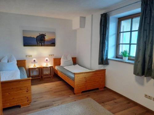 1 dormitorio con 2 camas y ventana en Moarhof Holzhausen, en Holzhausen