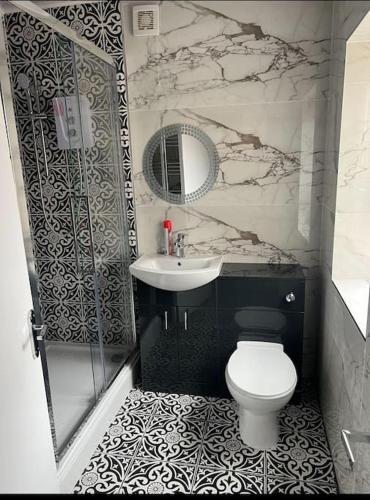 a bathroom with a toilet and a sink and a mirror at 4 Bedroom House, Central City Location in Newcastle upon Tyne