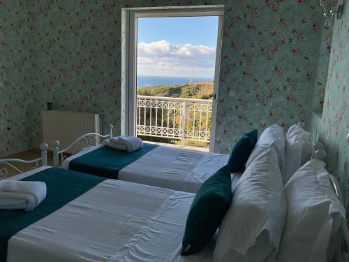 two beds in a room with a large window at Villa Kaminia Rose private pool & Jacuzzi in Ratzaklíon