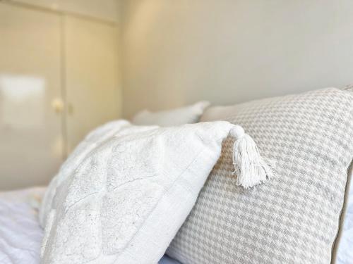 a bed with a white pillow with a white comforter at Solhaus - Modern 1BR by Towradgi Beach in Towradgi