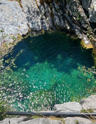 a large pool of water with rocks in it at Vilat Pllumaj in Gropat e Selcës