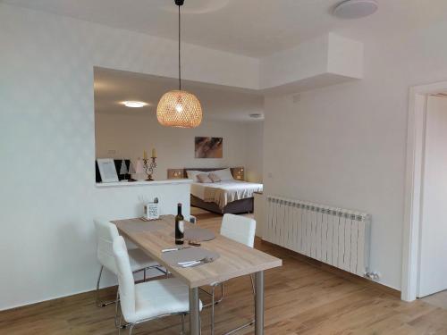 a dining room with a table and chairs and a bedroom at Studio Apartman Nika in Višnjan