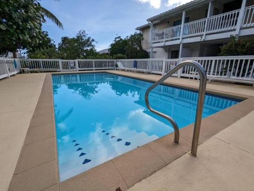 a swimming pool with a metal rail next to a building at Queen's Landing Island Paradise in Christiansted