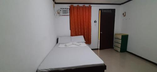 niewielka sypialnia z białym łóżkiem i oknem w obiekcie Subangan Room 6 w mieście Burgos